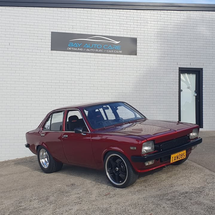 A red Holden Torana parked under the Bay Auto Care sign at the workshop