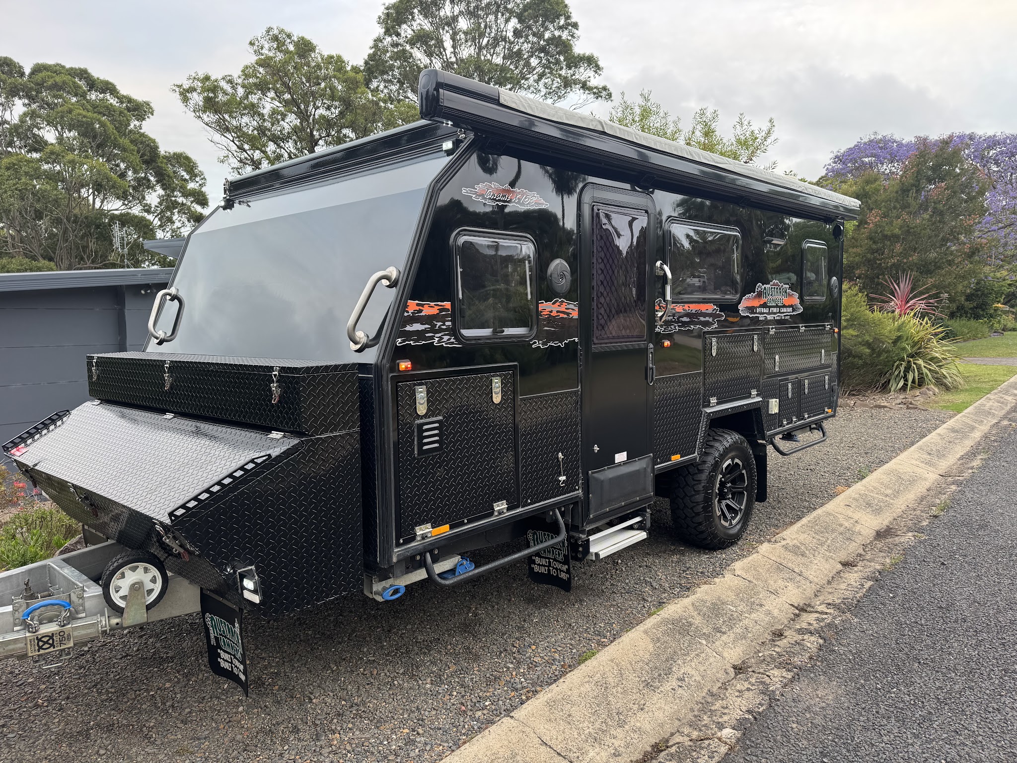 A black off road hybrid camper trailer cleaned and polished