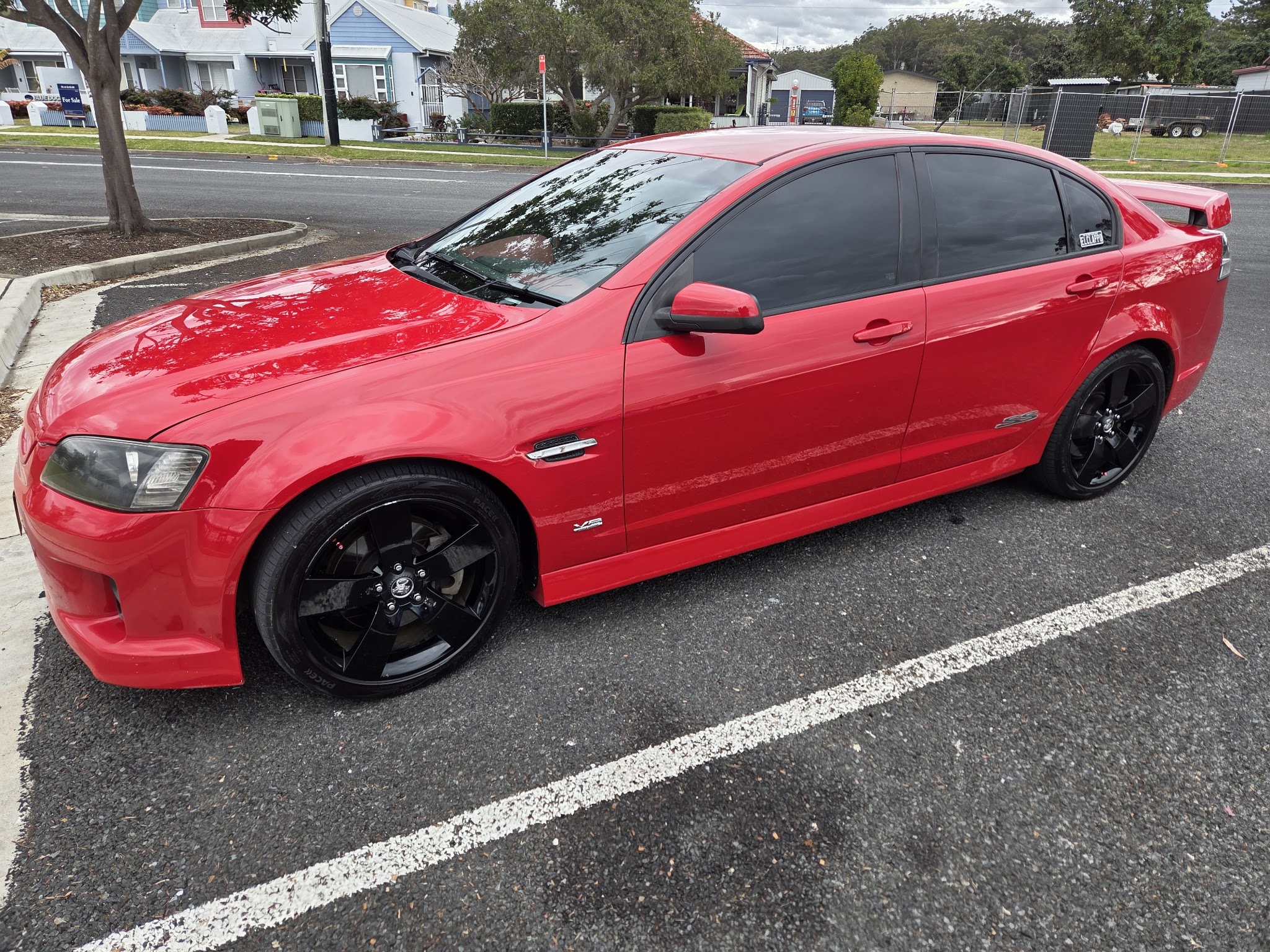 A red Holden Commodore SS detailed and gleaming at the kerb